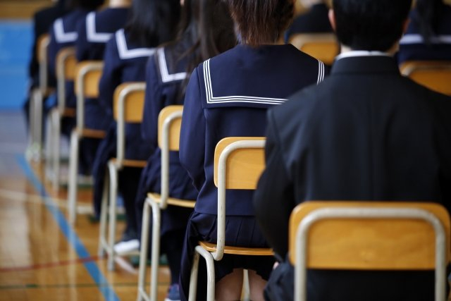 椅子に座って整列している中学生